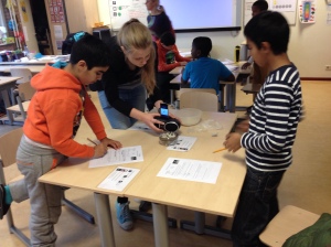 Sylvia helpt de leerlingen bij het uitvoeren van het experiment 'springerig geluid'.